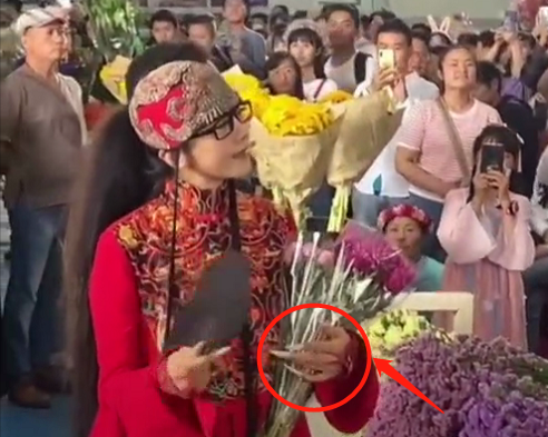 63岁杨丽萍一袭红衣逛花市被拍 男性友人贴心为其提袖子